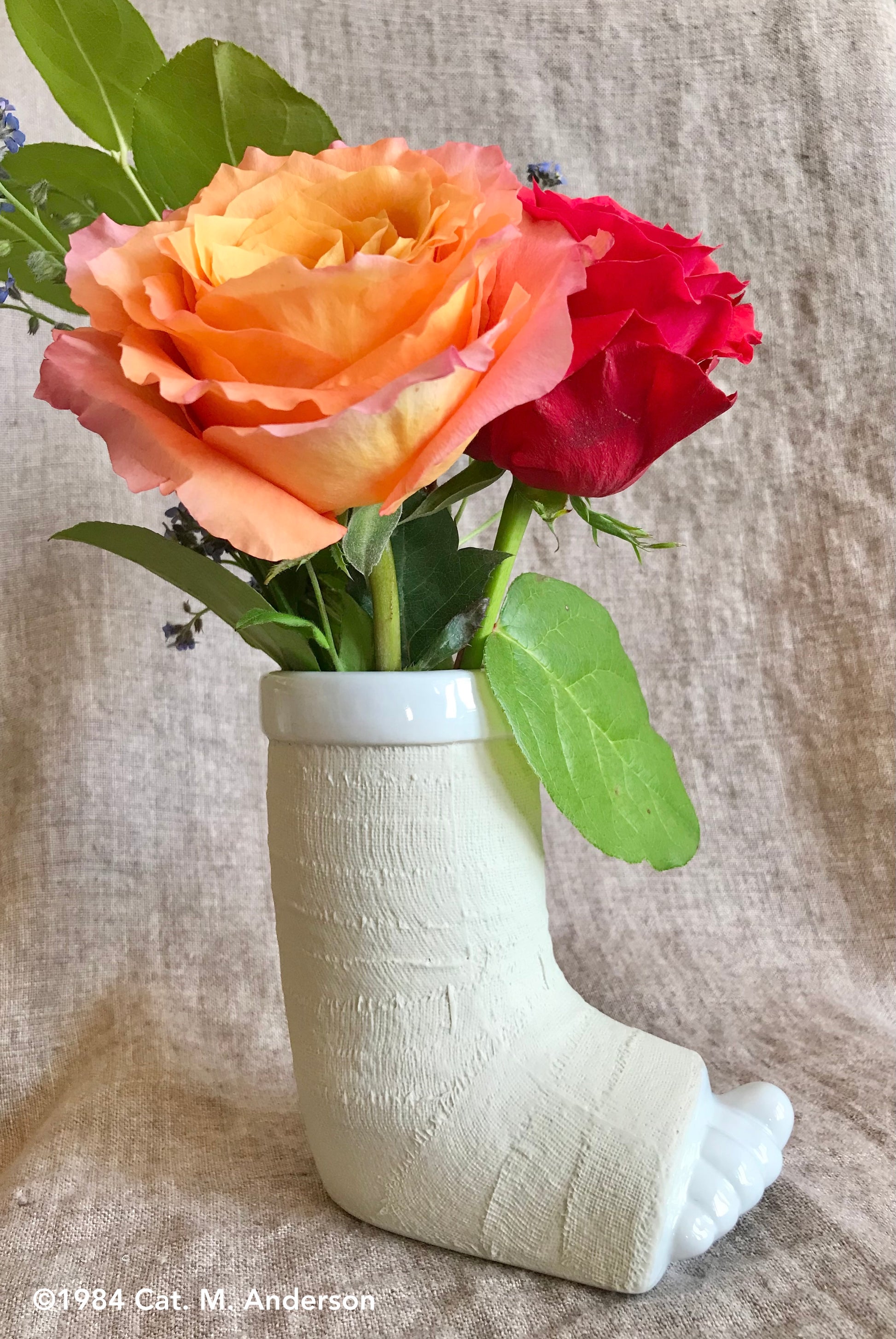 porcelain foot in a cast vase or mug with flowers, side view - break a leg